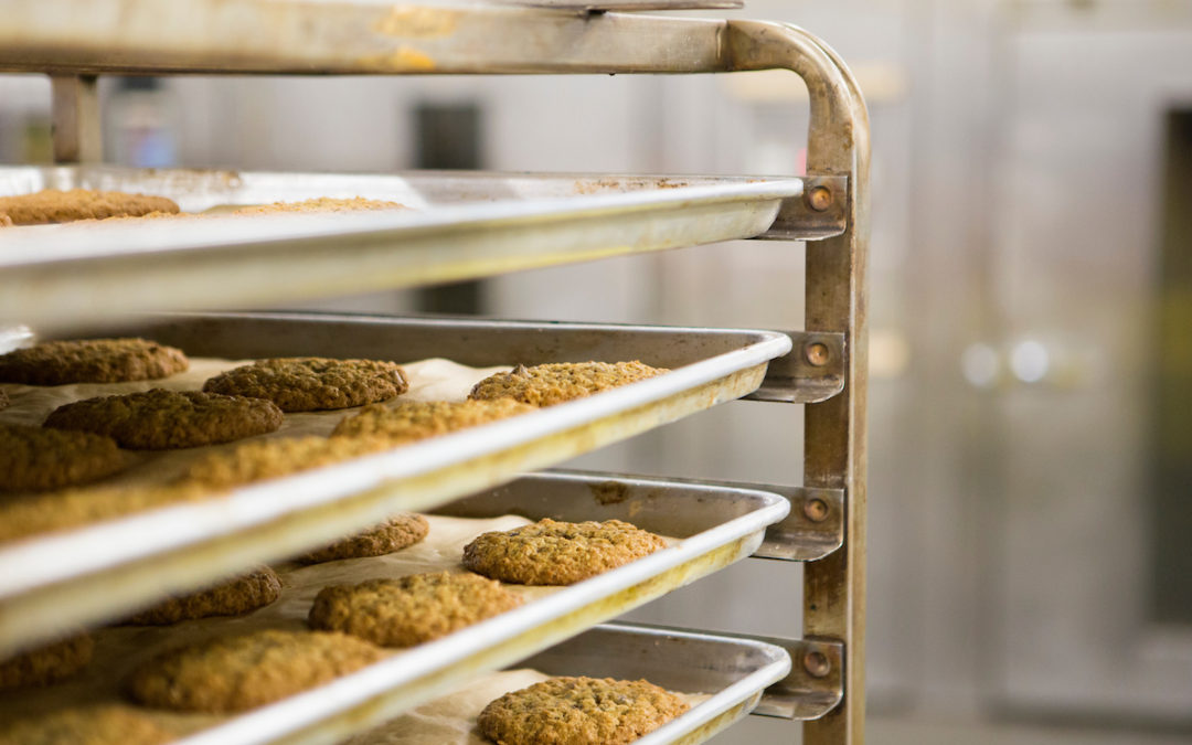 A photo of a cookie rack, taken inside Little Rae's, a wholesale bakery.